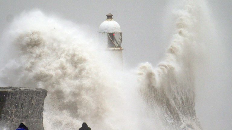 Waves crash over the seafront in Porthcawl in Wales. Pic: PA