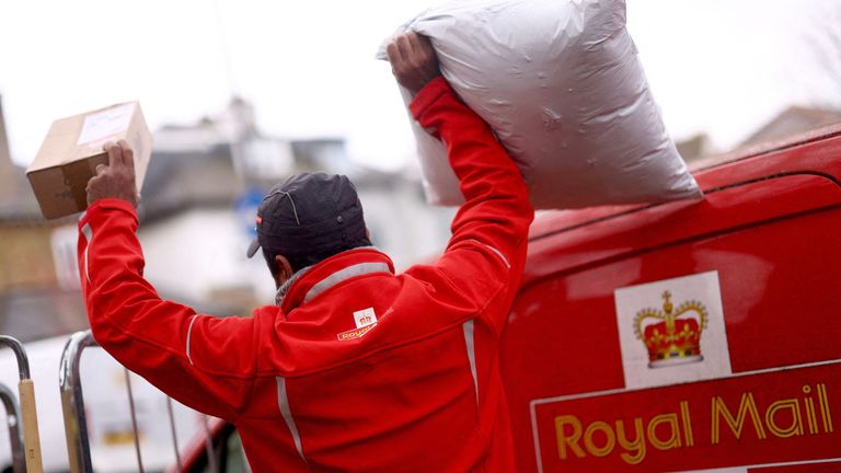 A Royal Mail worker loads a van at Streatham delivery office.
Pic: Reuters