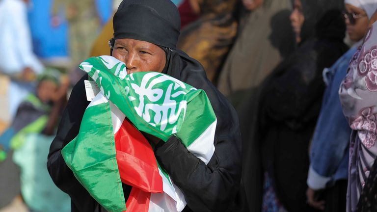 A woman kiss the Somaliland flag as she waits to cast her vote during the 2024 Somaliland presidential election at a polling station in Hargeisa, Somaliland, Wednesday, Nov. 13,2024. (AP Photo/Abdirahman Aleeli)