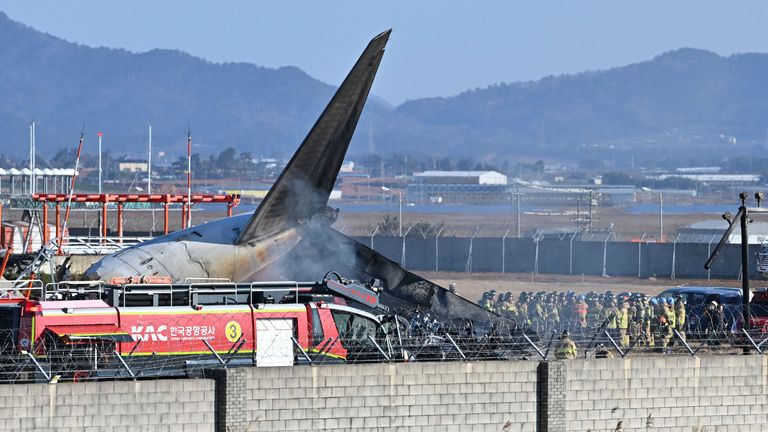 Firefighters and rescue team members work in the aftermath of the crash.
Pic: Lee Young-ju/Newsis/AP