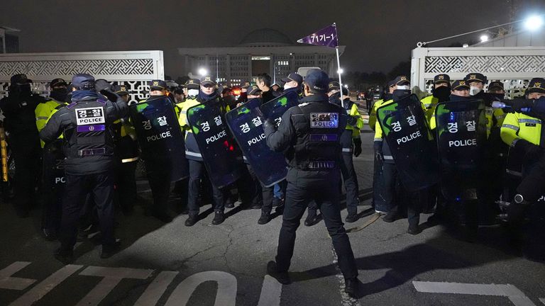 Police officers stand guard in front of the National Assembly in Seoul, South Korea, Tuesday, Dec. 3, 2024. (AP Photo/Lee Jin-man)