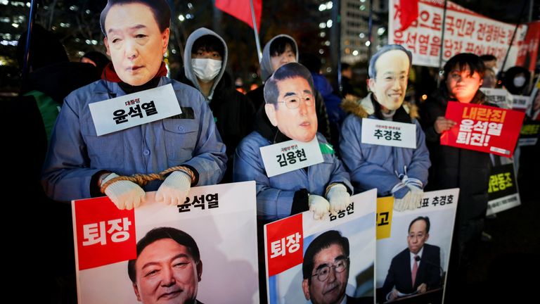 Anti-government protesters wear masks of officials including President Yoon Suk Yeol in Seoul. Pic: Reuters