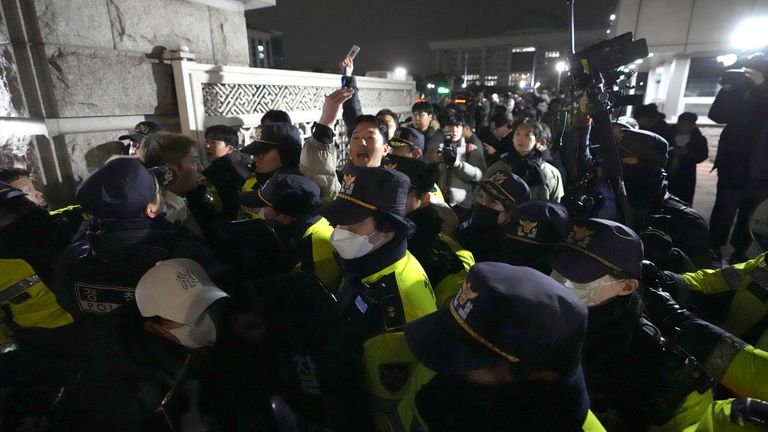 Police officers stand guard in front of the National Assembly in Seoul, South Korea.
Pic: AP