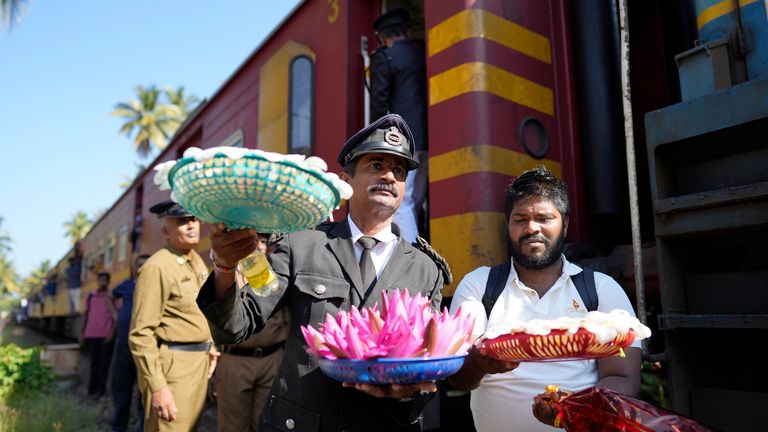 Railway workers carry flowers to offer at a memorial built in memory of those who died.
Pic: AP