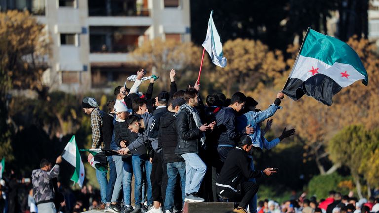 People celebrate after fighters of the ruling Syrian body ousted Syria's Bashar al-Assad, in Damascus. Pic: Reuters

