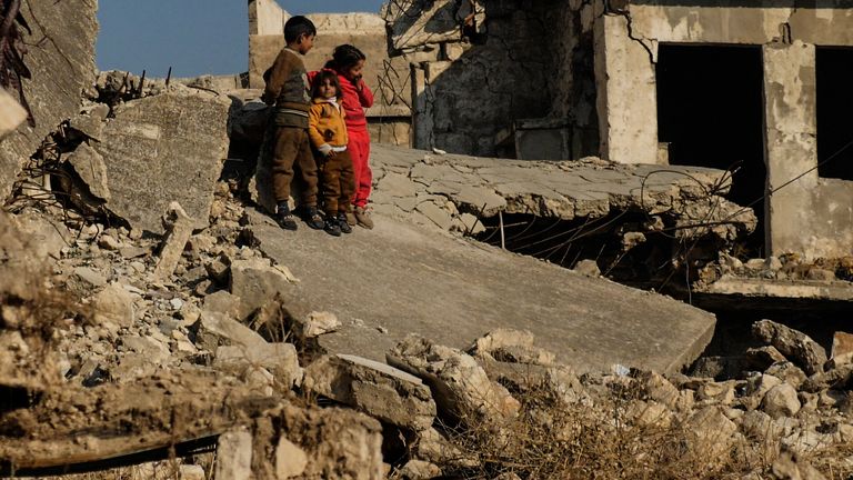 Local children play among the rubble