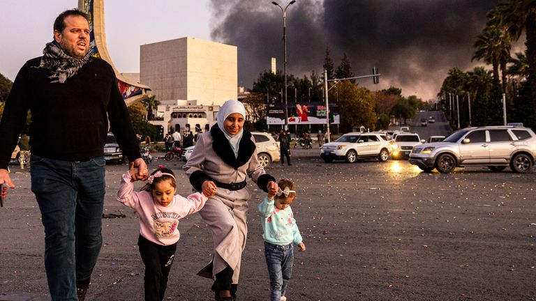 Rook stijgt op als mensen arriveren om de val van de Syrische regering te vieren, in Damascus, Syrië, zondag 8 december 2024. (Ugur Yildirim/Dia Photo via AP)