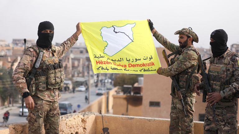 SDF fighters fly their flag after capturing Deir el Zor in eastern Syria on 7 December. Pic: Reuters