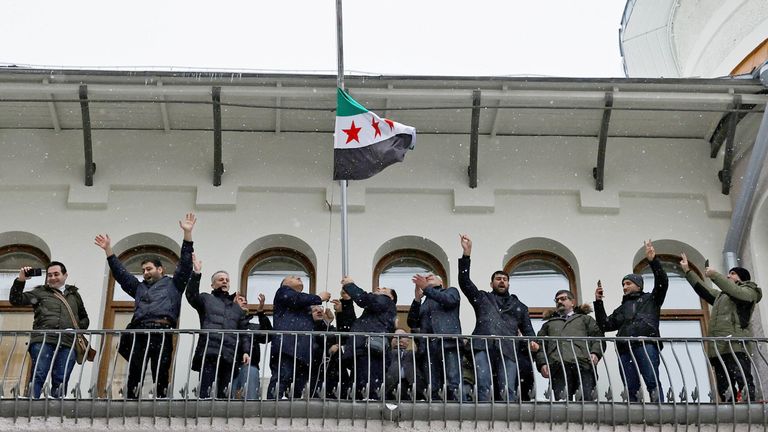 People who introduced themselves as members of the Syrian diaspora install the Syrian opposition flag on the building of the Embassy of Syria in Moscow, Russia.
Pic: Reuters