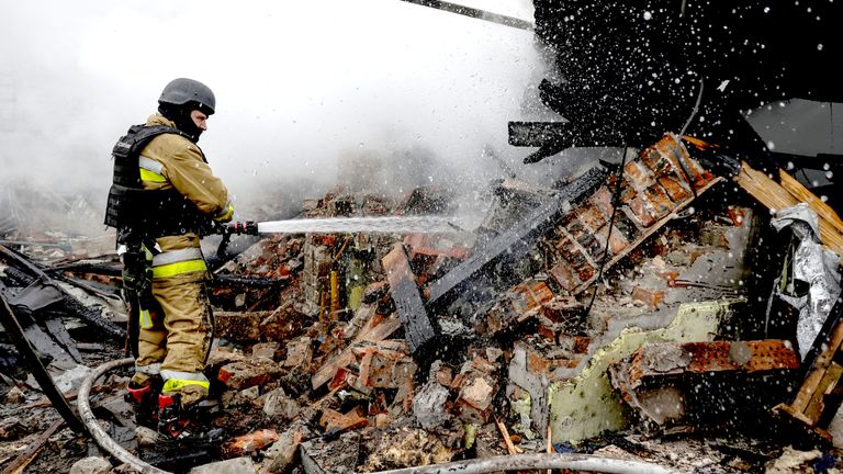 A firefighter works at the site of residential buildings hit by a Russian drone strike in Kharkiv.
Pic: Reuters