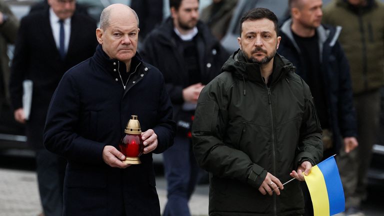 Ukraine's President Volodymyr Zelenskiy and German Chancellor Olaf Scholz walk to visit a makeshift memorial place displaying Ukrainian flags with the names of fallen service members, at the Independence Square, amid Russia's attack on Ukraine, in Kyiv, Ukraine December 2, 2024. REUTERS/Gleb Garanich