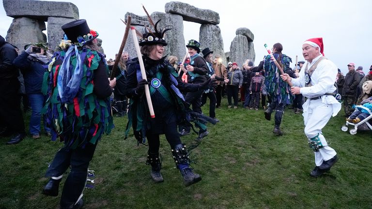 Morris dancers perform in front of the stones as people take part in the winter solstice celebrations during sunrise at the Stonehenge prehistoric monument on Salisbury Plain in Wiltshire. Picture date: Saturday December 21, 2024.