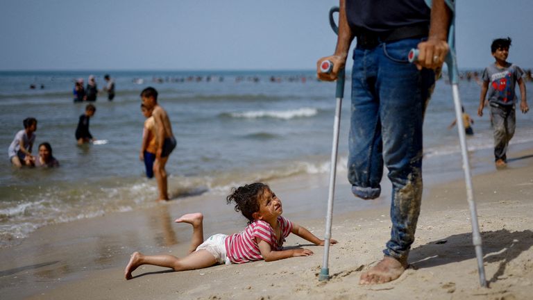 A child looks on as Palestinians enjoy the beach on a hot day, amid the ongoing conflict between Israel and Hamas, in Rafah, in the southern Gaza Strip, April 24, 2024. REUTERS/Mohammed Salem        SEARCH "REUTERS BEST 2024" FOR THIS STORY. SEARCH "REUTERS YEAR-END" FOR ALL 2024 YEAR END GALLERIES.          TPX IMAGES OF THE DAY