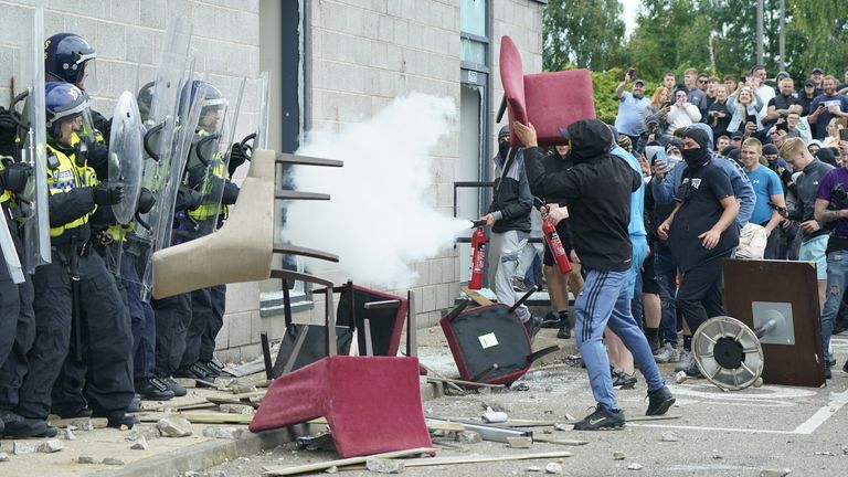 A chair is thrown at police officers as trouble flares during an anti-immigration protest outside the Holiday Inn Express in Rotherham, South Yorkshire. Picture date: Sunday August 4, 2024.