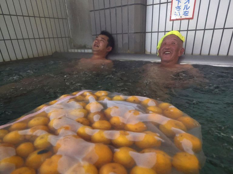 People take a Yuzu-yu bath steeped with yuzu citrus at a hot spring facility in Suzu City, Ishikawa Prefecture on December 21, 2024, the winter solstice. Japanese tradition say that you do not catch a cold for one year if you take yuzu bath on solstice day.( The Yomiuri Shimbun via AP Images )