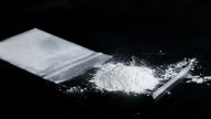 ketamine drugs and plastic straw on bag of white powder on black wood background.Drug epidemic concept.