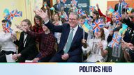 Keir Starmer waves as he sits with Ukranian school children as they communicate over video link with a primary school in Liverpool. Pic: Reuters 