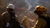Smoke rises from a hotspot as firefighters work to stop it from spreading. Pic: Reuters