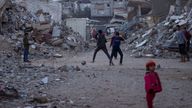Palestinian children play next to buildings destroyed by Israeli army strikes in Khan Younis, Gaza Strip, Tuesday, Jan. 7, 2025. (AP Photo/Abdel Kareem Hana)