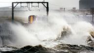 A train makes its way through strong winds as high waves batter the shore near Saltcoats, North Ayrshire, as the remnants of Hurricane Katia hit British shores.