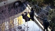 Police officers cut through a wire fence set up at the entrance to Yoon Suk Yeol's official residence.
Pic: Reuters