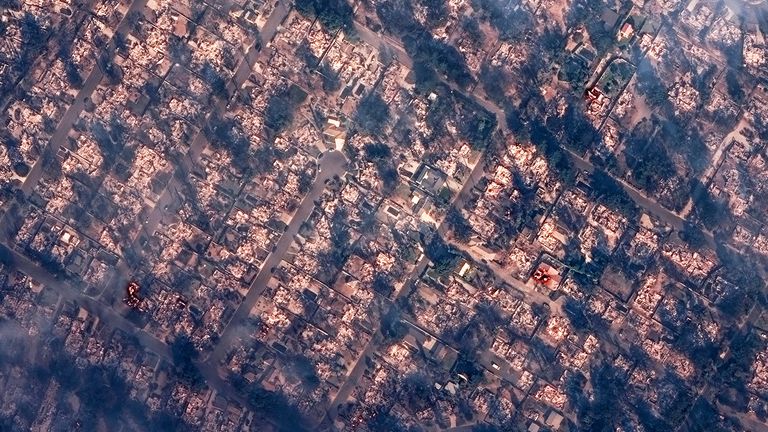 A satellite image shows smoke covering houses after devastating wildfires, in Altadena, California
Pic: Maxar/Reuters