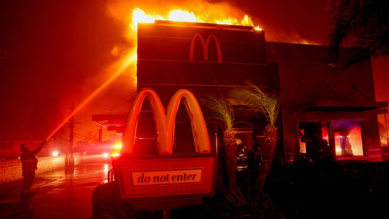 Firefighters work to extinguish flames as the Eaton Fire burns in Pasadena, California, U.S. January 7, 2025. REUTERS/Mario Anzuoni 