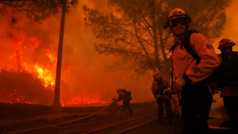 Firefighters battle the advancing Palisades Fire in the Pacific Palisades neighborhood of Los Angeles, Tuesday, Jan. 7, 2025. (AP Photo/Etienne Laurent)