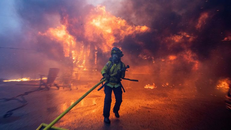 A firefighter battles the Palisades Fire amid a windstorm in Los Angeles, California.
Pic: Reuters