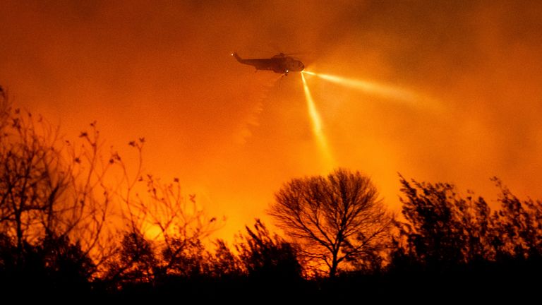 A helicopter drops water while fighting the Auto Fire in Ventura County, Calif., on Monday, Jan. 13, 2025. (AP Photo/Noah Berger)