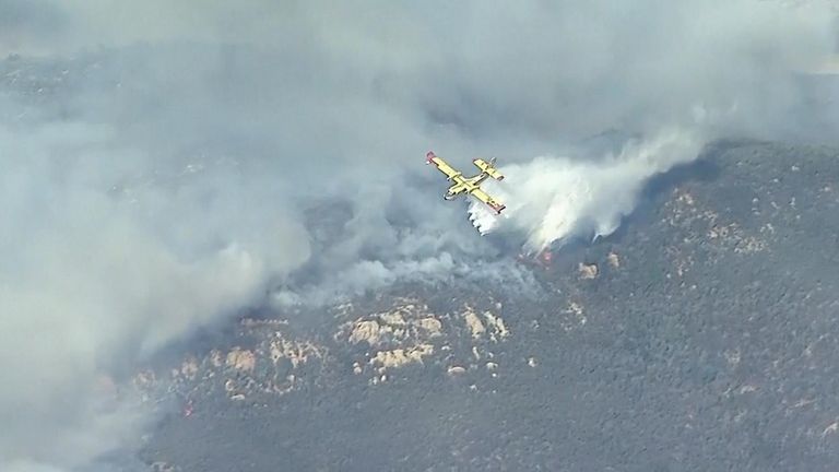 A plane dropping water on the Hughes fire