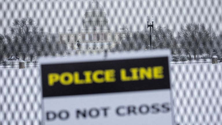 A sign is seen in a security fence near the U.S. Capitol, on the day of a joint session of the Congress to certify Donald Trump's election, as a winter storm that brought snow, ice and freezing temperatures to a broad swath of the U.S. arrived, in Washington, U.S. January 6, 2025. REUTERS/Marko Djurica

