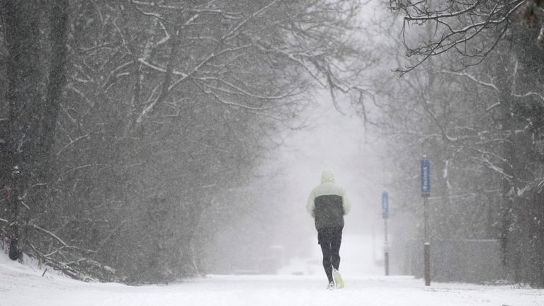 A person runs down a trail during a winter storm  in Cincinnati.
Pic: AP