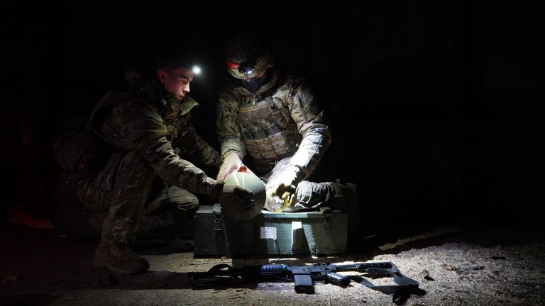 Marines preparing a thermobaric weapon to be attached on to a bomber drone                    