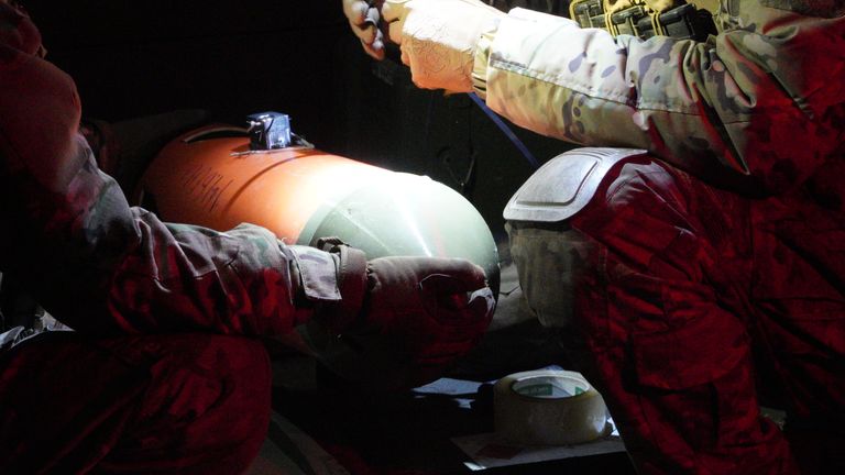 Marines preparing a thermobaric weapon to be attached on to a bomber drone