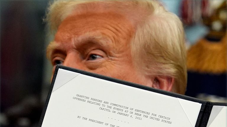 Donald Trump holds an executive order ordering the release of 6 January rioters. Pic: AP