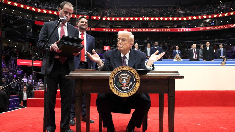 Donald Trump sings the Executive Order on Free Speech at his inaugural parade. Photo: Reuters