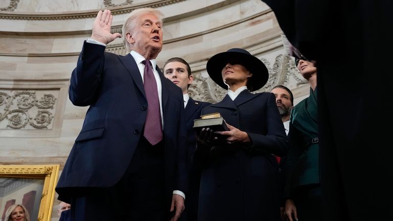 Mr Trump is sworn in by Chief Justice Roberts with his wife Melania and son Barron by his side. Pic: AP