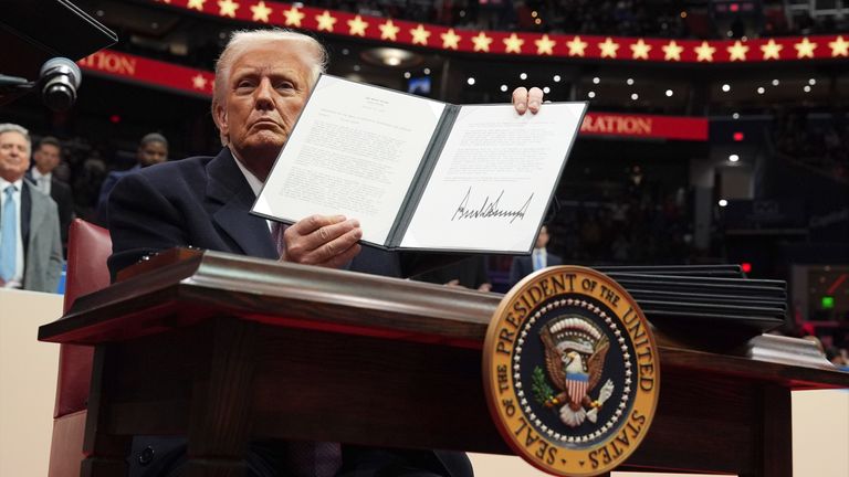 Donald Trump signs an executive order on a hiring freeze.
Pic: AP