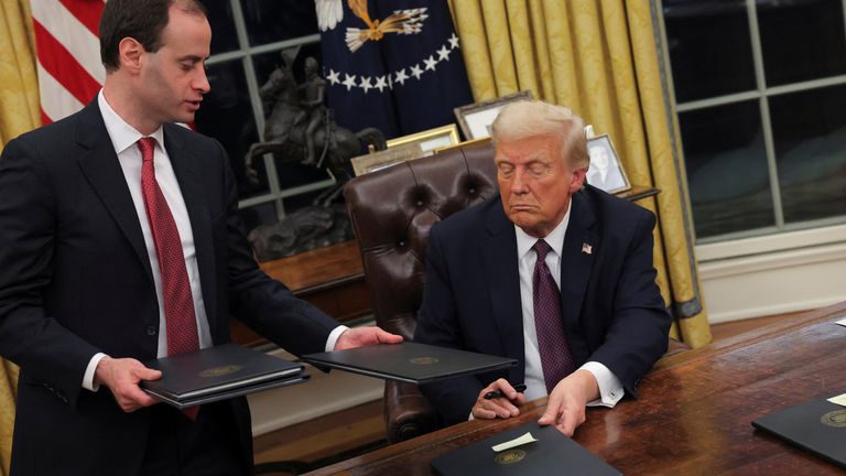 U.S. President Donald Trump signs documents as he issues executive orders and pardons for January 6 defendants in the Oval Office at the White House on Inauguration Day in Washington, U.S., January 20, 2025. REUTERS/Carlos Barria