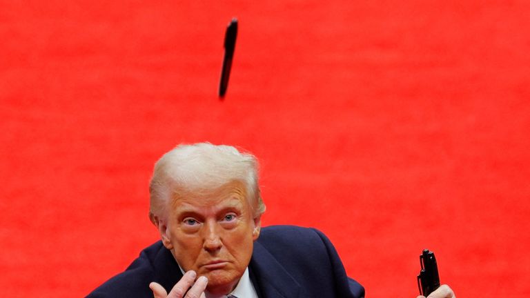 Donald Trump throws a pen after he signed executive orders. Pic: Reuters