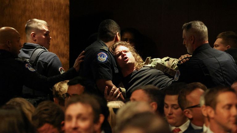 Security personnel remove a protester as Pete Hegseth, U.S. President-elect Donald Trump's nominee to be secretary of defense, testifies before a Senate Committee on Armed Services confirmation hearing on Capitol Hill in Washington, U.S., January 14, 2025. REUTERS/Evelyn Hockstein