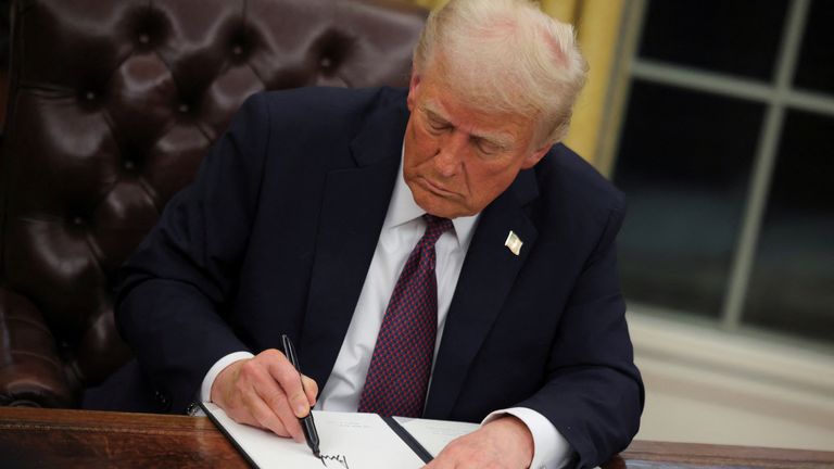 U.S. President Donald Trump signs documents as he issues executive orders and pardons for January 6 defendants in the Oval Office at the White House on Inauguration Day in Washington, U.S., January 20, 2025. REUTERS/Carlos Barria

