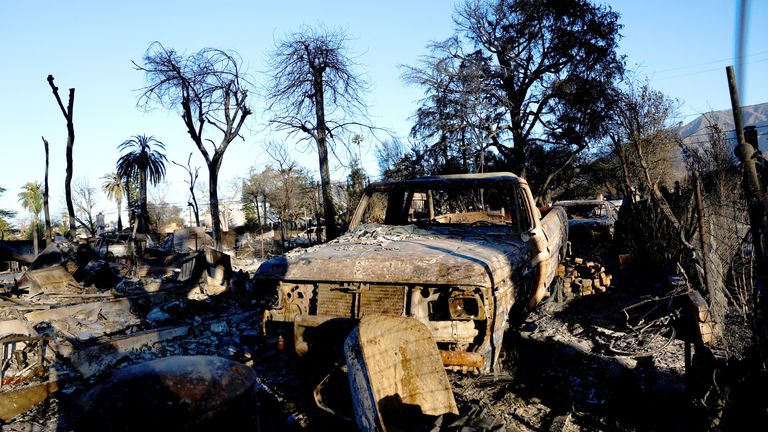 A burnt car is parked near the remains of a devastated home, as the Eaton fire continues, in Altadena, California, U.S. January 13, 2025. REUTERS/Shannon Stapleton