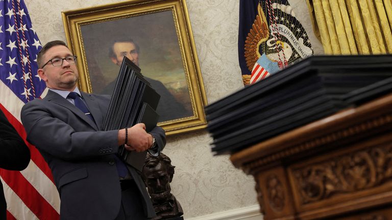 Member of Trump staff carries his executive orders on inauguration day. Pic: Reuters