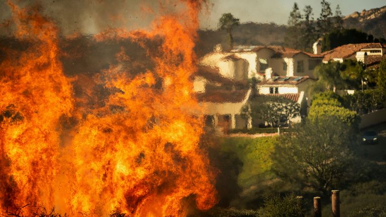 Flames rise as the Palisades Fire advances on homes in the Pacific Palisades neighbourhood of Los Angeles, Tuesday, Jan. 7, 2025. (AP Photo/Ethan Swope)