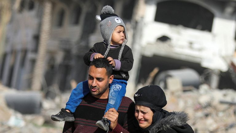 Displaced Palestinians walk past the rubble as they attempt to return to their homes, following a delay in the ceasefire between Israel and Hamas over the hostage list, in the northern Gaza Strip, January 19, 2025. REUTERS/Dawoud Abu Alkas TPX IMAGES OF THE DAY

