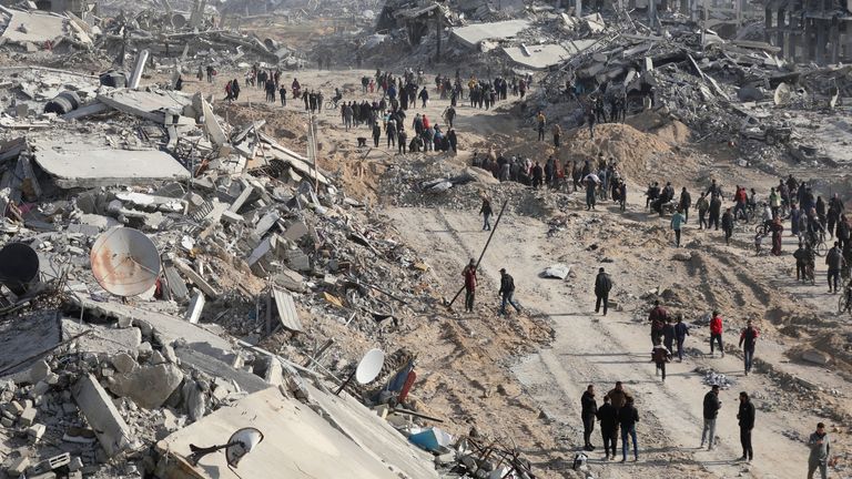 Displaced Palestinians walk past the rubble as they attempt to return to their homes, following a delay in the ceasefire between Israel and Hamas over the hostage list, in the northern Gaza Strip, January 19, 2025. REUTERS/Dawoud Abu Alkas TPX IMAGES OF THE DAY

