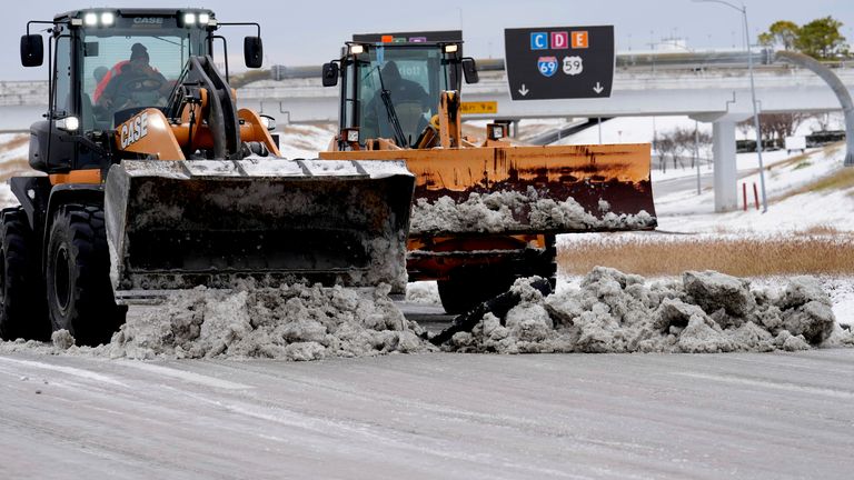 Workers clearing snow from the roadways at the closed George Bush Intercontinental Airport on Tuesday, Jan. 21, 2025, in Houston. (AP Photo/David J. Phillip)