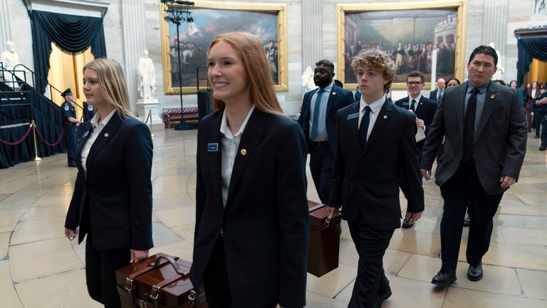 Pages carrying boxes holding the Electoral College votes walk through the Rotunda to the House Chamber for a joint session of congress to confirm the Electoral College votes, at the Capitol, Monday, Jan. 6, 2025, in Washington. (AP Photo/Jose Luis Magana)